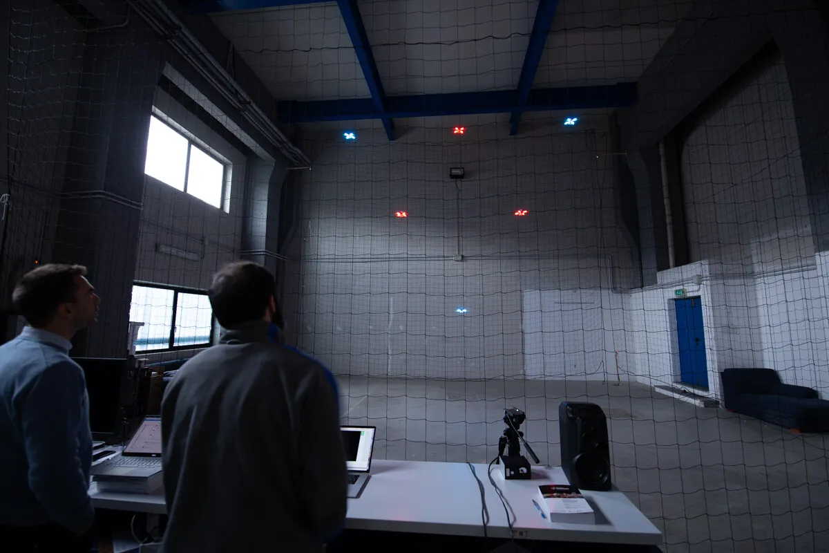 Volo di prova indoor con droni colorati in uno spazio industriale